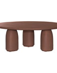 Lantara coffee table in cinnabar clay finish with rounded top and three rounded sculptural legs.