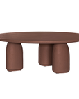 Lantara coffee table in cinnabar clay finish with rounded top and three rounded sculptural legs.