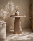 Lantara side table in nomad dune finish styled with a ceramic vase in a warm neutral interior setting.