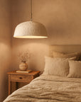 Lindiweh Pendant by KULALA Living in a serene, earthy-toned bedroom with natural linen bedding and rustic timber bedside table