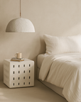 KULALA Living Lindiwhe Pendant light and Niche Side Table styled in a soft neutral bedroom with minimal furnishings and layered natural textures
