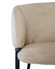 Lumo dining chair in bone with soft upholstered seat and curved backrest on slim black legs shown in a clean minimal setting.