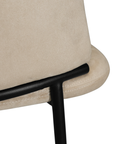 Lumo dining chair in bone with soft upholstered seat and curved backrest on slim black legs shown in a clean minimal setting.