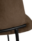 Lumo dining chair in cocoa with soft upholstered seat and curved backrest on slim black legs shown in a clean minimal setting.