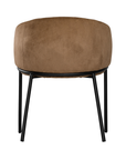 Lumo dining chair in hazelnut with soft upholstered seat and curved backrest on slim black legs shown in a clean minimal setting.