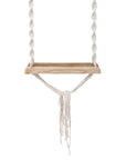 A handcrafted wooden swing with intricate macramé rope detailing, designed for indoor or outdoor relaxation. The bohemian-inspired hanging seat adds a natural, playful element to any space