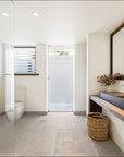 Mara basket in natural handwoven finish styled beneath a timber bathroom vanity with stone flooring and soft neutral interior tones