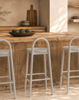 Milo bar chairs in White paired with a natural timber kitchen island in a warm Mediterranean inspired interior.