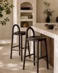 Milo barchair in espresso finish styled beside a textured stone island creating a warm refined kitchen setting with natural earthy tones.