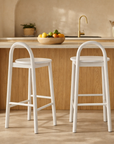 White Milo Barchair with curved silhouette styled at a timber kitchen island in a light filled modern australian home