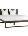 A sleek modern bed frame crafted from dark oak, featuring a minimalist open-base design. The bed is styled with crisp white linen and plush pillows, offering a refined and contemporary bedroom aesthetic