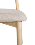 Contemporary wooden dining chair with a natural timber frame and an upholstered seat and backrest in neutral fabric, blending comfort and style for modern interiors.