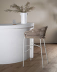 Stylish woven bar stool with a neutral-toned rope seat and a sleek white metal frame, perfect for contemporary kitchen or outdoor bar settings