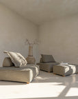 A serene living space featuring a moss modular lounge set, designed for effortless comfort and modern relaxation. Styled with a textured vase and neutral décor, bathed in warm natural light