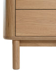 Molly Bedside Table in natural oak with rounded edges and two drawers, styled in a minimalist bedroom setting