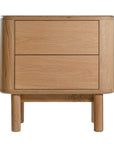 Molly Bedside Table in natural oak with rounded edges and two drawers, styled in a minimalist bedroom setting