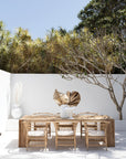 Nakula blonde rattan dining chairs styled around a timber table in a sunlit mediterranean inspired australian courtyard setting