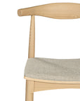 Kulala Living natural wood dining chair featuring a sculpted backrest and a lightly upholstered seat in a neutral fabric. A blend of minimalist design and organic materials, perfect for modern dining spaces.