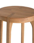 A sleek natural oak round stool featuring a minimalist design with subtly curved legs. Crafted from solid oak with a clear finish, this versatile piece functions as a stool or side table, adding a modern touch to any space