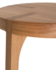 A sleek natural oak round stool featuring a minimalist design with subtly curved legs. Crafted from solid oak with a clear finish, this versatile piece functions as a stool or side table, adding a modern touch to any space