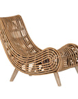 A sculptural natural rattan lounge chair with a curved, low-profile silhouette and sleek wooden legs. The woven design adds texture, while the deep seat and ergonomic shape offer comfort and relaxation