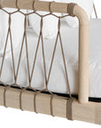 Natural rope lounge chair with white cushions, featuring a light timber frame and modern coastal aesthetic.