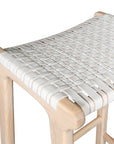 A handcrafted natural wood bar stool featuring a woven white leather seat, designed for a relaxed and stylish coastal-inspired space.