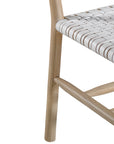 A stylish natural wood dining chair featuring a woven white leather seat and backrest, blending modern design with organic textures