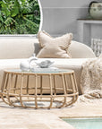 Outdoor setting featuring a rope weave coffee table with a glass top, styled with neutral decor and a curved sofa, creating a serene and sophisticated poolside lounge space