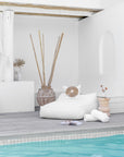 White outdoor beanbag by the poolside, styled with a white decorative cushion, rustic wooden side table, and natural decor accents, creating a serene and stylish relaxation space.
