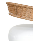 A rattan armchair featuring a curved backrest and a plush white upholstered seat. This coastal-inspired piece combines natural textures with modern comfort, ideal for relaxed living spaces