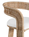A natural rattan dining chair with a curved backrest and a white upholstered cushion. The woven design and sturdy frame create a stylish and comfortable seating option, perfect for modern coastal or relaxed interiors
