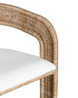 A natural rattan dining chair with a curved backrest and a white upholstered cushion. The woven design and sturdy frame create a stylish and comfortable seating option, perfect for modern coastal or relaxed interiors