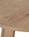 Round teak cafe table with a natural finish and angled legs, perfect for relaxed modern interiors
