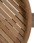 The Kulala Living Round Teak Coffee Table, crafted from solid teak with a slatted tabletop and sturdy block legs. This timeless design adds warmth and natural texture to any living space.