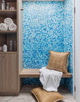 Seagrass cushions styled on a wooden spa bench with blue mosaic tiles, adding natural texture to a serene and luxurious wellness space