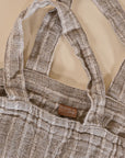A generously sized striped linen market bag with a relaxed, slouchy design and exterior pocket. The neutral-toned fabric and soft texture create a timeless, effortless style