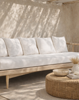 Tamala three seater sofa with soft white cushions styled in a serene mediterranean inspired australian courtyard setting
