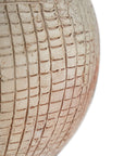 Terracotta table lamp featuring a textured spherical base with intricate grid detailing and a wide conical fabric shade in a neutral tone
