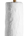A textured paper mache white table lamp with elongated sculptural base and neutral linen shade, adding a refined and organic touch to any interior space
