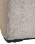 Curved upholstered ottoman with natural textured fabric and subtle black feet, ideal for contemporary living spaces