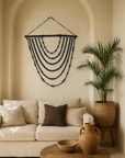 Black Tumelo String Wall Art handcrafted from teak beads, styled in a neutral living space with curved alcove, linen sofa, timber coffee table and earthenware accents from KULALA Living