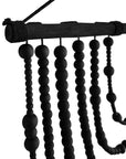 Black wooden beaded wall hanging with layered strands, creating a bold decorative statement for modern interiors