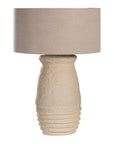 Sculptural table lamp with a cream textured paper mace base and neutral linen shade, adding organic elegance to any space