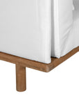 A contemporary armless sofa with plush white cushions and a sturdy natural teak wood frame. This minimalist lounge piece offers versatile seating, perfect for modern living spaces or outdoor settings