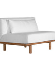 A contemporary armless sofa with plush white cushions and a sturdy natural teak wood frame. This minimalist lounge piece offers versatile seating, perfect for modern living spaces or outdoor settings