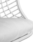 A stylish white hanging chair with an open-weave design, suspended by a natural rope and featuring a plush white cushion for ultimate relaxation
