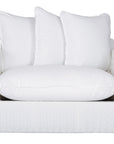 A contemporary white woven sofa with plush, generously filled cushions, offering both comfort and style for a refined coastal or modern living space.