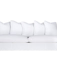 A contemporary white woven sofa with plush, generously filled cushions, offering both comfort and style for a refined coastal or modern living space.