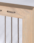 Wooden accent chair with white cushions and sleek spindle detailing, perfect for modern coastal and relaxed living spaces